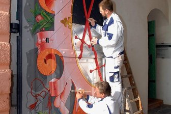 450 Jahre Schloss Augustusburg: Umbrüche und Ungewissheit in der Wende-Zeit - Handwerker auf Schloss Augustusburg in den 2000er-Jahren: Malermeister Heiko Jämlich aus Gornau verpasst mit seinem Mitarbeiter Christoph Heldt den Schlosstoren denkmalgerecht ein schmuckes Aussehen. 