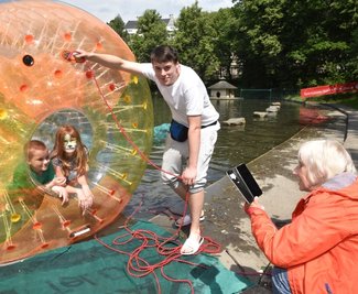 Oma Margit Kannegießer hält die Fahrt ihrer Enkel Jason und Fabiane, hier unterstützt von Oskar Reichelt, im Wasser-Bumber mit ihrem Handy fest. 