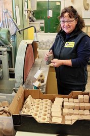 Mitarbeiterin Uta Hansen schleift die Bauteile für die Räucherhäuschen.