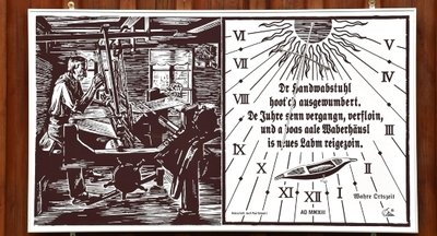 Am Viebig 13 ist die jüngste Sonnenuhr zu sehen. Sie gleicht einem alten Holzschnitt.