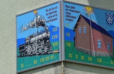 Am Haus Am Bahndamm 1 zeigt die Sonnenuhr Bahnerhäusl und Dampflok.