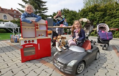 Zur Erstauflage des Wüstenbrander Garagen- und Hoftrödelmarktes am Samstag bauten Helene (links) und Pauline Lötzsch mit Papa Alex im Hof eine Stadt auf. Der Verkauf alter Spielsachen, wie einer kleinen Spielküche und eines Kinder-Cabriolets, sollte die Urlaubskasse weiter auffüllen.