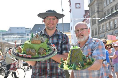 Roman Strauch (links) arbeitet als Rangierer bei der Regiobahn Bitterfeld Berlin (RBB) Captrain. Passend dazu hat er einen Hut mit Mini-Eisenbahn, Kirche und Berg mit Bergsteigern kreiert, daneben Matthias Strauch.
