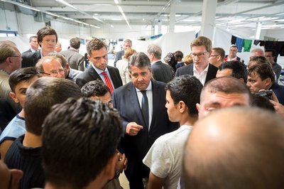 Vizekanzler Sigmar Gabriel (Mitte) besuchte am Montag die Notunterkunft für Flüchtlinge im ehemaligen Praktiker-Baumarkt in Heidenau.