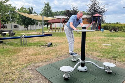 Bürgermeister Udo Eckert testet den Hüfttrainer. Hier in Berthelsdorf können Kinder spielen und Eltern gleichzeitig trainieren.