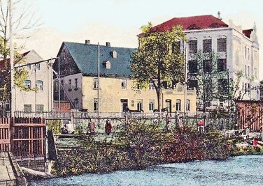 Die Ansichtskarte von 1912 zeigt das Restaurant, den Turnbereich (links) und das Schulgebäude (rechts) vom Mittelweg aus.