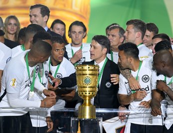 Trainer Niko Kovac (M) von Eintracht Frankfurt und seine Spieler jubeln über dem Sieg hinter dem Pokal bei der Siegerehrung auf dem Podium.