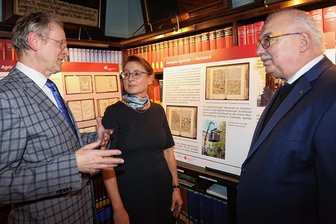 465 Jahre altes Buch von Georgius Agricola aus Bestand der Zwickauer Ratsschulbibliothek restauriert - Der Chef der Ratsschulbibliothek Lutz Mahnke, die Vorsitzende des Vereins "Freunde der Ratsschulbibliothek", Heike Angermann, und der Reinsdorfer Bürgermeister Steffen Ludwig (von links) vor der Ausstellung zu Agricola und seinem Buch "Vom Bergwerk XII Bücher". 