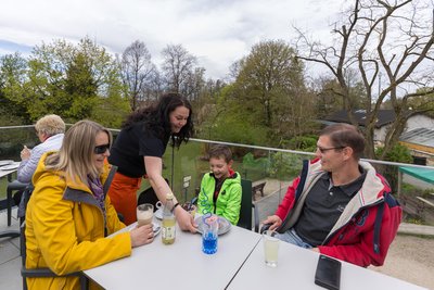 Marilyn Riedel bringt dem siebenjährigen Leon sowie Jörg und Kathrin Berner aus Zwickau im Tiergarten Falkenstein Kaffee und Kuchen sowie warme Milch.