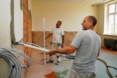Thomas Thümmel (r.) und Daniel Hajdu, Mitarbeiter einer Chemnitzer Baufirma, sind in einem Unterrichtszimmer zugange. 