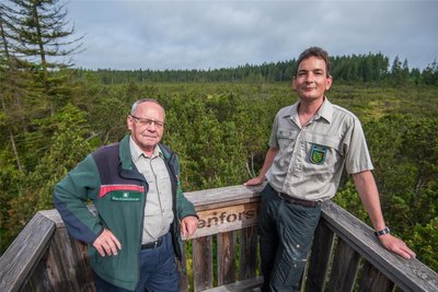 Ingolf Zirnstein, Sachbearbeiter Waldökologie und Naturschutz bei Sachsenforst (links), und Forstbezirksleiter Johannes Riedel genießen den Ausblick von der Plattform am Kleinen Kranichsee.