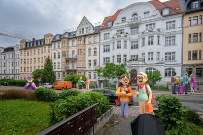 Mehr los als sonst: Auf dem Kaßberg in Chemnitz wimmelt es mittlerweile vor Touristen. So begegnet man beispielsweise beim Spazieren auf der Erich-Mühsam-Straße immer wieder Besucherinnen und Besuchern der Stadt (hier mit KI generiert).