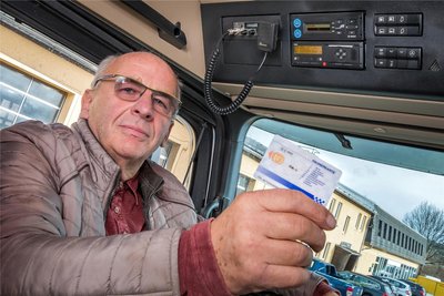 Andreas Börner in einem seiner Lastwagen: Er hält eine Fahrerkarte in der Hand. Sie wird zur Anmeldung benutzt.