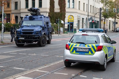 Einsatzfahrzeuge stehen auf einer Hauptstraße nahe der Synagoge. 