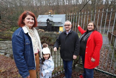 Odette Lamkhizni, Ortschaftsratsvorsitzende von Halsbach, ihre Tochter Soraya sowie Udo Klemm und Kati Kluge vom Heimatverein (v. l.) an der Brücke, die über die Mulde zum Schwarzen Haus führt.