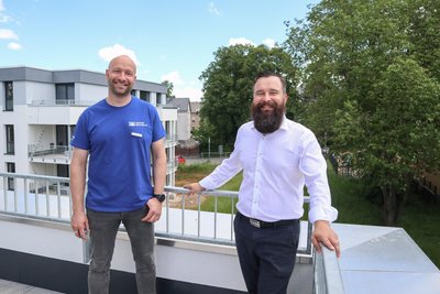 Raymond Uhlig (links) von der Volksbank und Alexander Franz von KPM Bau auf der Dachterrasse eines der neuen Häuser.