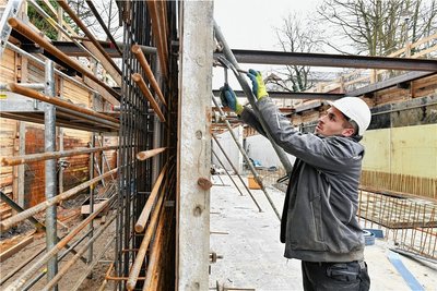 Almin Kollath von der gleichnamigen Schalungsbaufirma aus Dresden verschraubt Ankerstäbe an der Betonwand. 