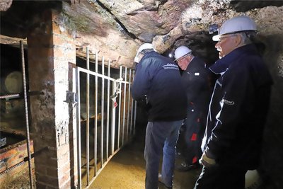 Uwe Nitschke, Michael Eßlinger und Knut Neumann (v. r.) vor dem Gitter, hinter dem der Freiberger Whisky lagert.