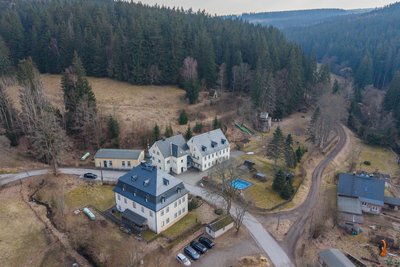 Zu dem weitläufigen Gelände gehören mehrere Gebäude, ein Spielplatz, ein Bolzplatz, ein kleines Schwimmbecken und der historische Hochofen. Vorn ist das Hammerherrenhaus zu sehen.