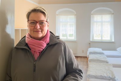 Anja Jost, die Schatzmeisterin des Vereins Hammerwerk Schmalzgrube, in einem der größeren Herbergszimmer.