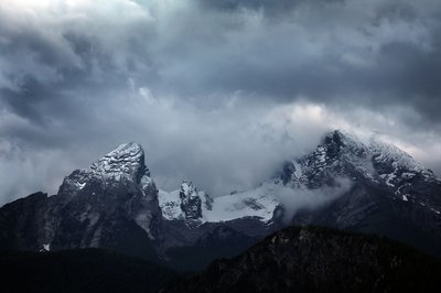 Wolkenverhangen ist der schneebedeckte Watzmann.
