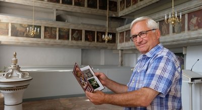 Die reich bebilderten Emporen (im Hintergrund) in der Hormersdorfer Kirche werden bei Führungen zum Tag des offenen Denkmals erläutert. Kirchenvorsteher Thomas Vorberg hat die Informationen in einer gerade erschienenen Publikation zusammengefasst. 
