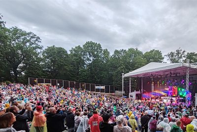 Die Zuschauer auf der Freilichtbühne in Regencapes und Ponchos. Das unfreundliche Wetter tat der Stimmung keinen Abbruch.