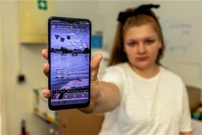Anastasiia Shevliakova zeigt auf ihrem Smartphone Bilder von der Flutkatastrophe am Staudamm nahe ihrer Heimatstadt Cherson. Dorthin hat sie Kontakte, die sie für die Spendensammlung nutzt.