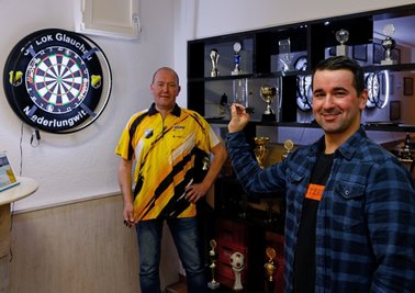 Triple-20 oder Bullseye? Journalist Robert Werner (rechts) probierte sich an der Dartscheibe des SV Lok Glauchau. Jörg Werner begutachtet aufmerksam, wo auf der Scheibe seine Steel-Darts landen werden. 