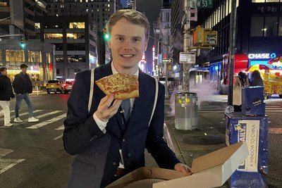 Lukas Hässner genießt ein Stück Pizza in New York.