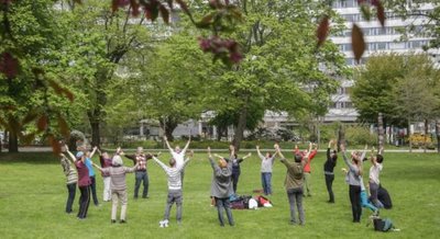 Interessierte um die Trainerin Ariane Lenk praktizieren Lach-Yoga im Stadthallenpark.