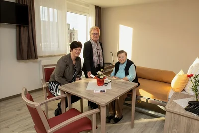 Bewohnerin Sigrid Krube freut sich über ihr neues Zuhause. Neben ihr: Einrichtungsleiterin Susen Rösch (links) und Kathrin Lämmerhirt von der Bauorganisation. 