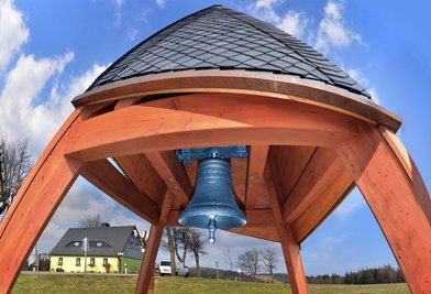 Eine Station des neuen Wanderwegs ist die 120 Kilogramm schwere alte Taufglocke von Deutschneudorf. Sie ist die kleinste der einstmals drei Kirchenglocken aus Stahl, die nach 140 Dienstjahren nun einen neuen würdigen Platz erhielten. 