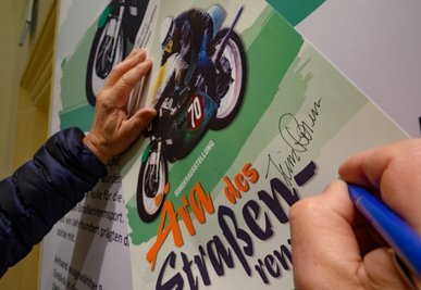 Einige Exemplare der Plakate für die neue Sonderausstellung "Ära des Straßenrennsports" im Motorradmuseum auf Schloss Augustusburg signierte Heinz Rosner - für die Fans, wie Schlosschefin Patrizia Meyn sagte.