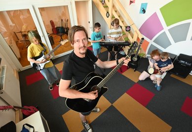An einem Dienstagnachmittag im Musikkombinat: Sven Heinrich unterstützt junge Besucher im neu eröffneten öffentlichen Probenraum "MusicX" beim Probieren an den Instrumenten.