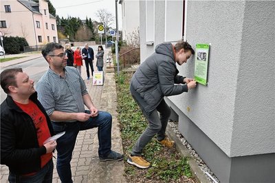 Maik Neubert, Mario Dugas und Niklas Neubert (von links) beim Anbringen der Tafel am Haus Kontakt, das Jugend- und Gemeindezentrum der Landeskirchlichen Gemeinschaft Auerswalde. 