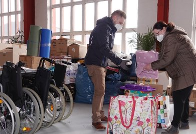 André Reppe hilft Monika Zergiebel beim Einsortieren ihrer Spenden in der großen Halle. 