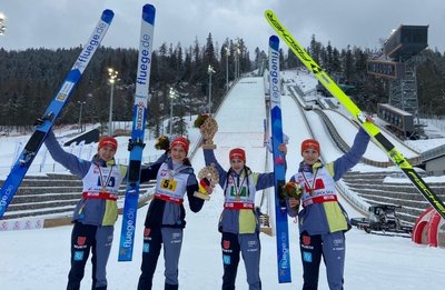 Lilly Kübler (2. von links) freut sich mit ihren Teamkameradinnen über Bronze im Mannschaftswettbewerb der Skispringerinnen. 