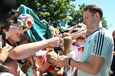 Manuel Neuer schreibt Autogramme. 