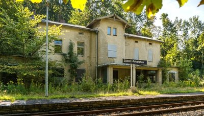 Wanderer, die auf dem Pockautalweg unterwegs sind, gehen direkt am verwaisten Bahnhofsgebäude vorbei. 