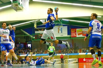 Aues Marc Pechstein beim Torwurf. Links Mario Fernandes (Hüttenberg) und Bjarki Gunnarsson (Aue), rechts Daniel Wernig (Hüttenberg), am Boden sein Mannschaftskamerad Ragnar Johannsson.