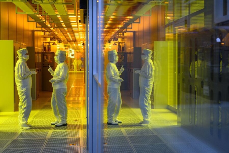 Mitarbeiterinnen des Chipkonzerns Infineon stehen im Reinraum der Chipfabrik.