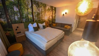 Der Blick in ein Musterzimmer mit Doppelbett und Einrichtung.
