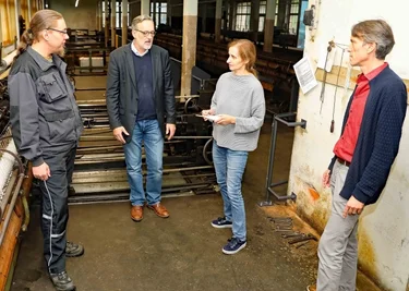 Philipp Kardel, Heike Schönfeld, Oliver Brehm und Lars Helling (von rechts) im Spinnsaal der Tuchfabrik Gebr. Pfau. 