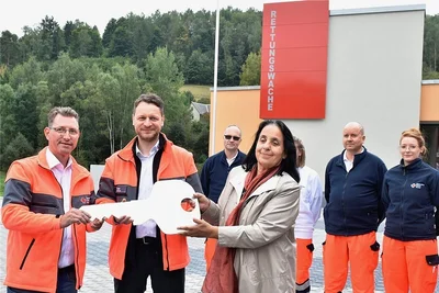 Symbolische Schlüsselübergabe durch Christina Uhlenhaut, Vize-Vorsitzende des Rettungszweckverbandes Südwestsachsen, an Rettungsdienstleiter Michael Höfer (links) und Gideon Türpe, Geschäftsführer des DRK Oelsnitz. 