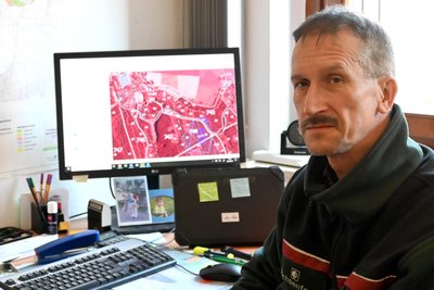 Revierleiter André Berger vor seinem Monitor, auf dem das Einsatzgebiet der Holzerntemaschinen angezeigt wird.