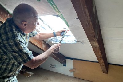 Tauben-Alarm in einem Reichenbacher Wohnblock. Mieter Hans-Dieter Denner an einem Dachfenster - noch vor Öffnen des Fensters gurrt es, als wären die Tauben in der Dachkammer.