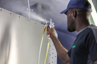 Omeras GmbH in Lauter-Bernsbach im Erzgebirge: Ein Mitarbeiter aus Gambia bereitet Stahlbleche für die Oberflächenbehandlung vor.