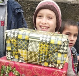 Ein Kind aus dem Kinderheim Mistice mit Geschenken. 
