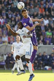 Aues Dimitrij Nazarov setzt sich im Kopfballduell gegen den Hamburger Orel Mangala durch.